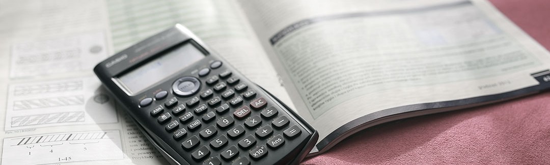 Graphing caulcuator and book, highlighting mistakes on tax returns